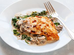 Chicken Florentine on white plate with fork.