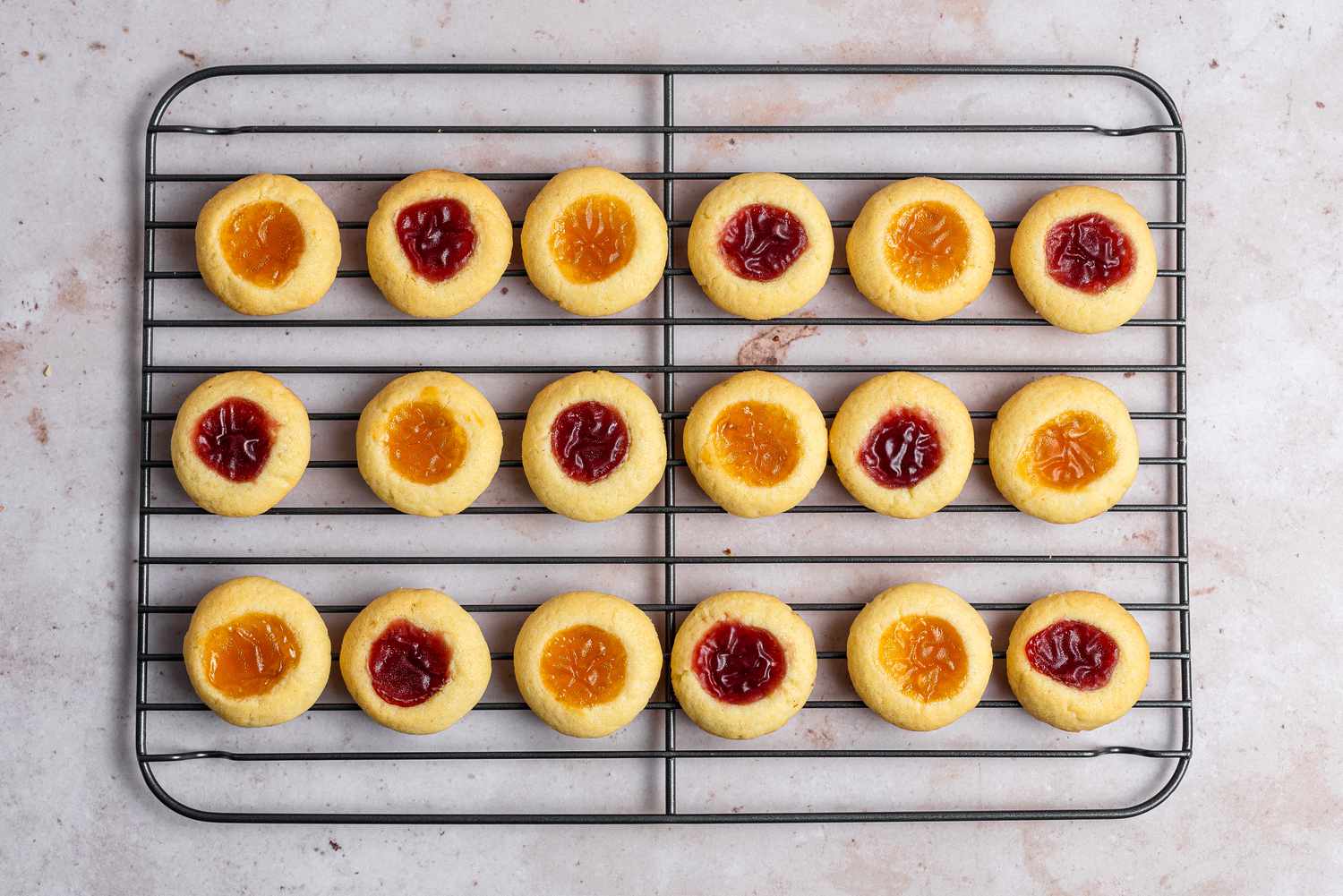 Overhead view of thumbprint cookies on a cooling rack.