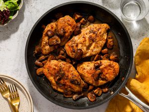 Four chicken breasts with balsamic mushrooms in a frying pan