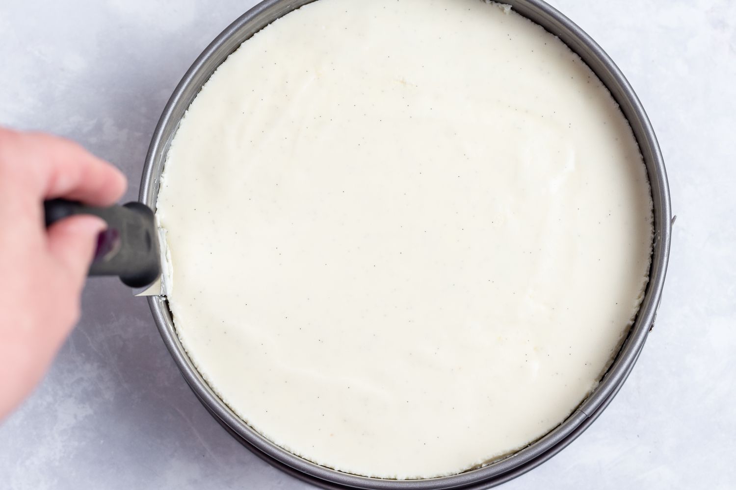 Running a knife around a springform pan for an easy no bake cheesecake.