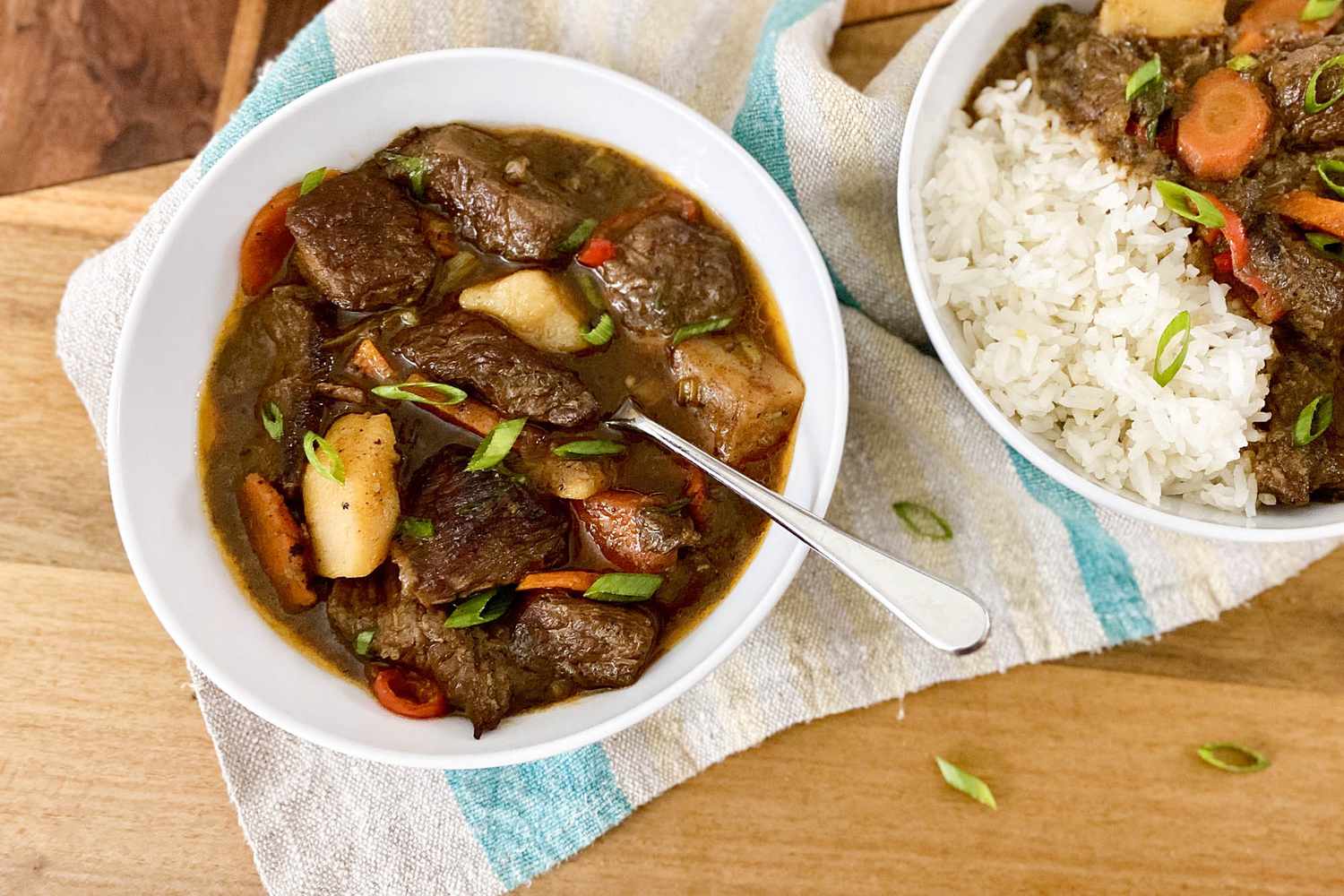 Jamaican Stewed Beef in two bowls and served with rice.