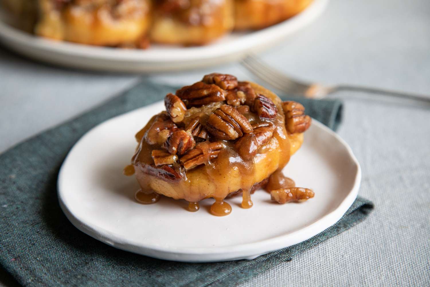 Cinnamon buns with pecans on a plate.