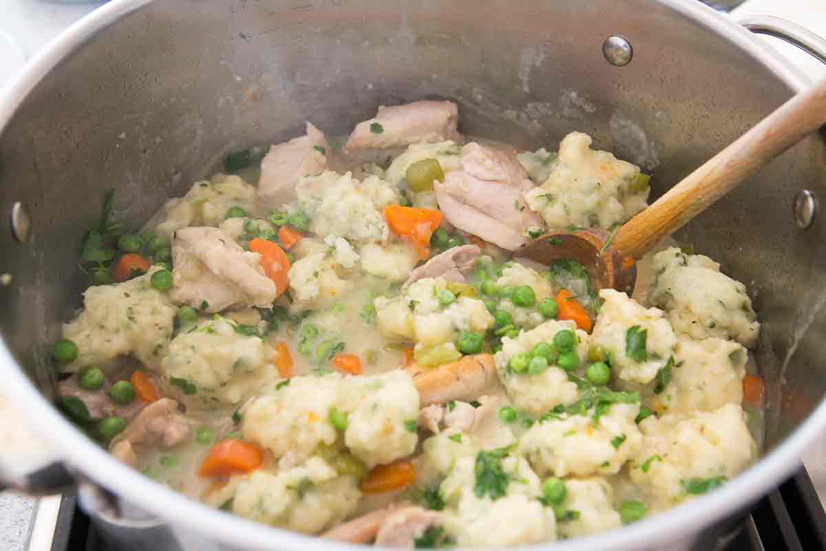 Stock pot with chicken and dumplings inside.