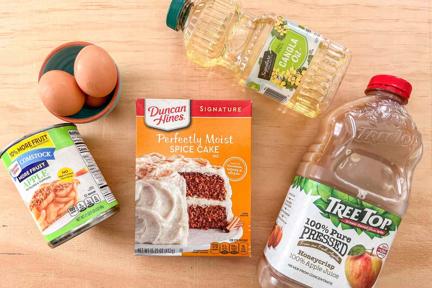 Ingredients for Days of Our Lives apple cake (L to R): bowl of uncracked eggs, canned apples, box of Duncan Hines Perfectly Moist Spice Cake, canola oil, and apple juice