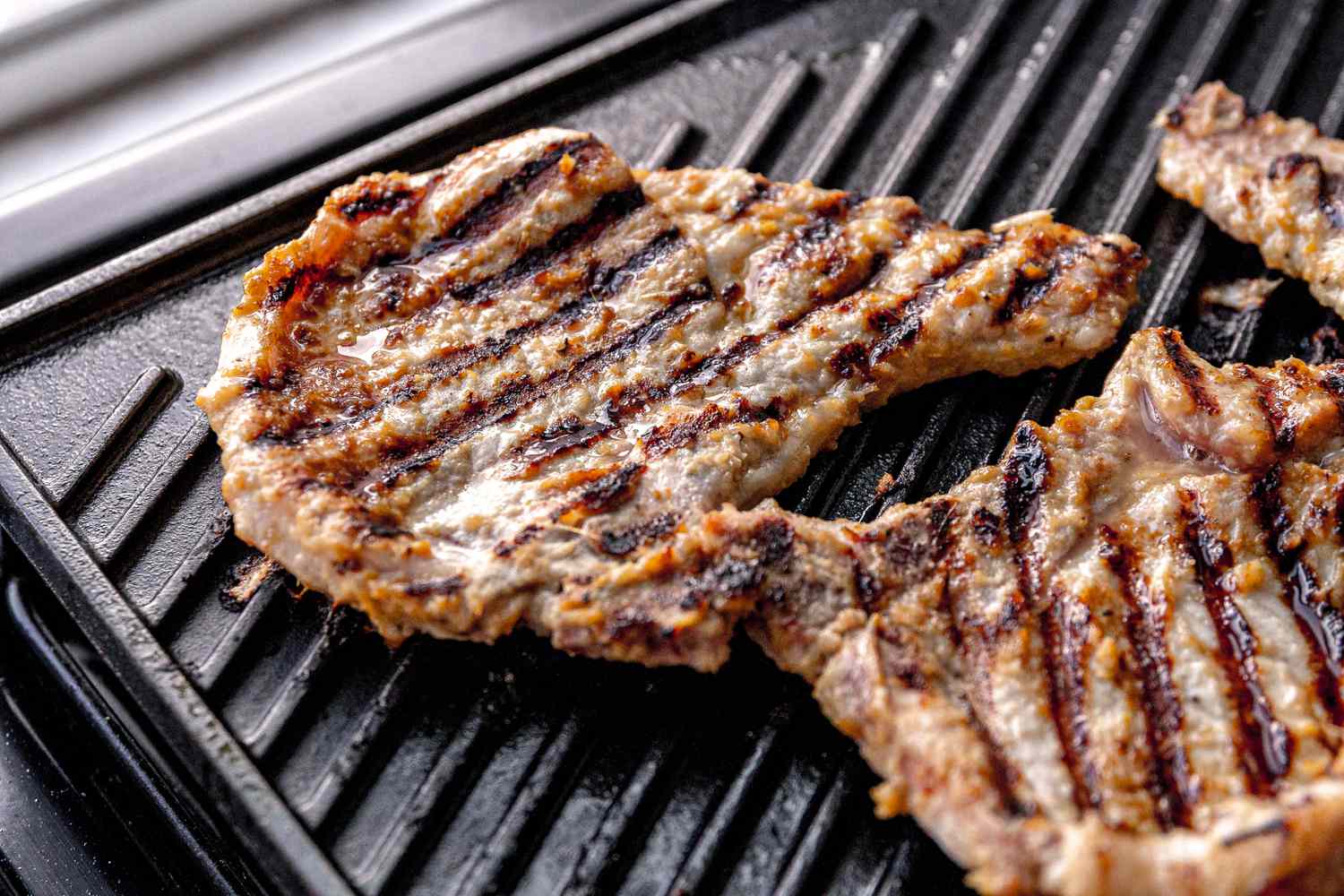 lemongrass pork chops cooking on a griddle