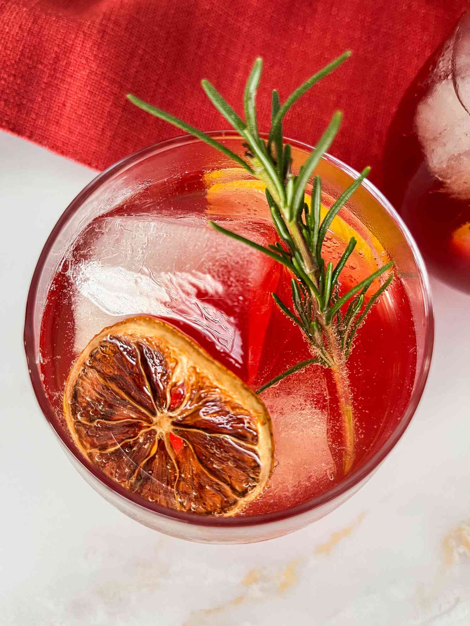 holiday punch in a glass with rosemary and dried citrus slice
