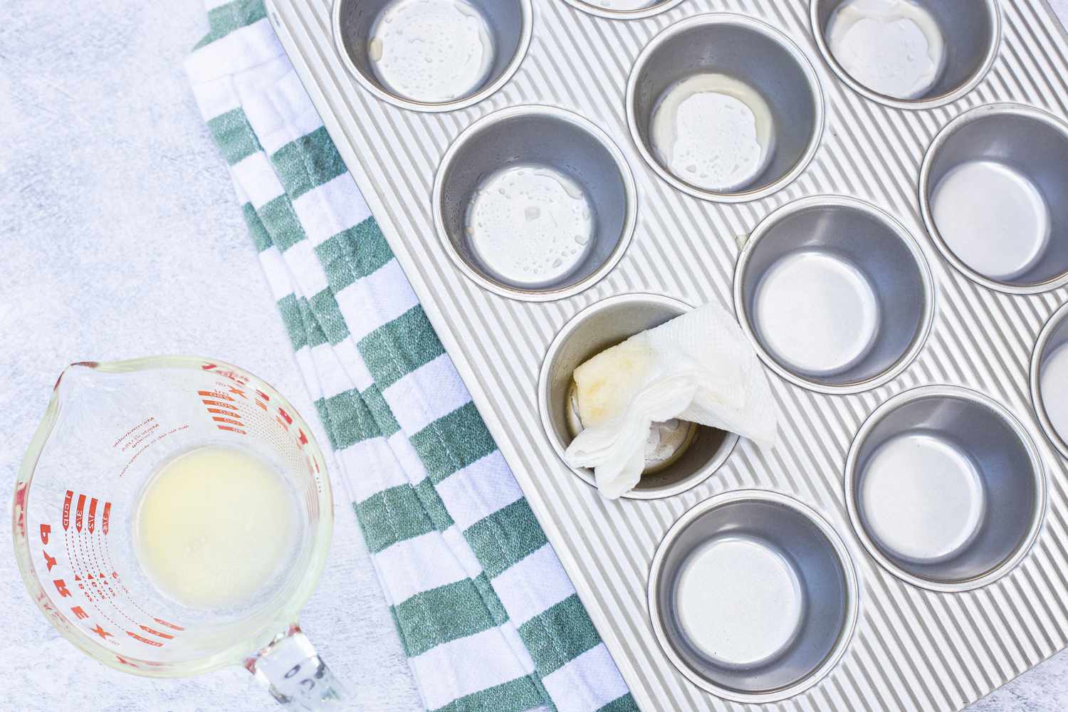 Grease Muffin Tin with Butter for Ham and Cheddar Egg Bites