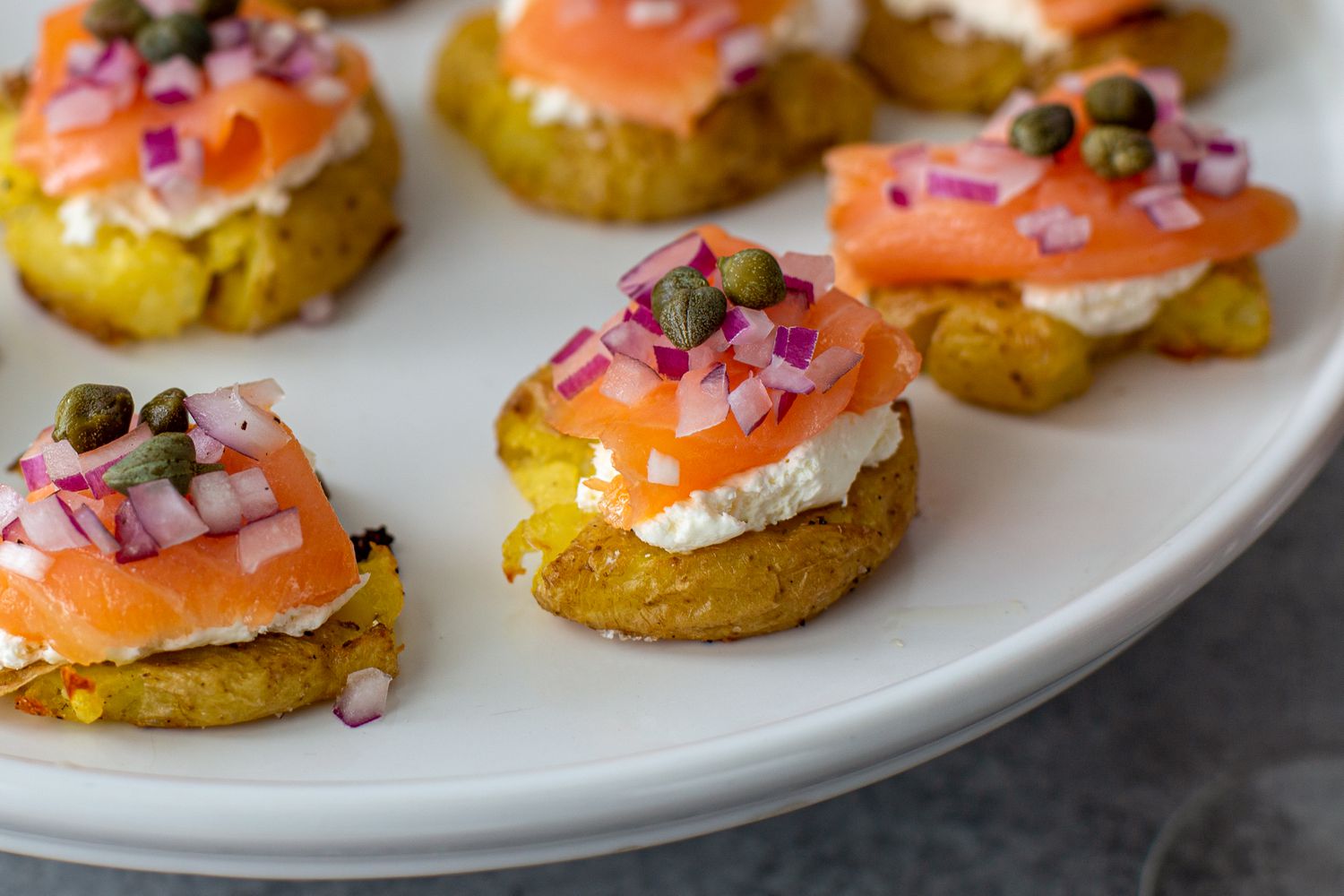 Close up of a platter of smoked salmon-topped potatoes.