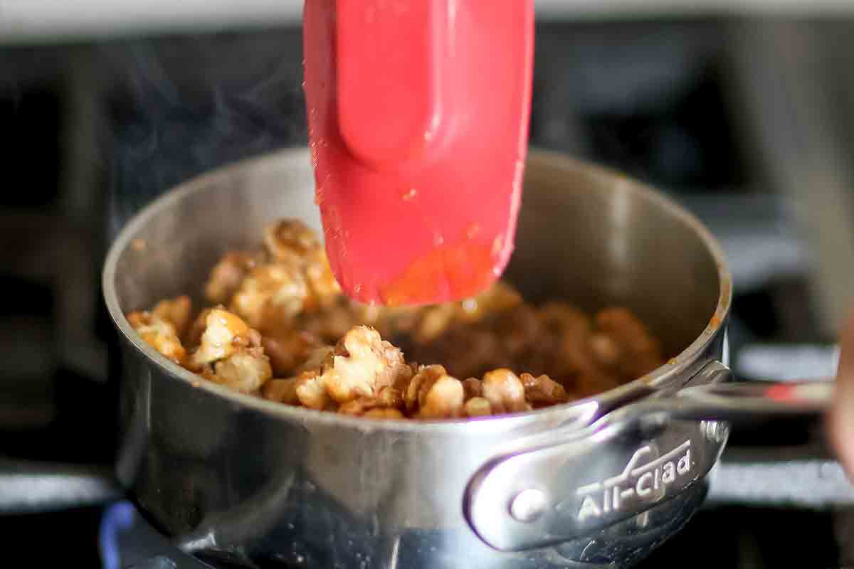 Walnuts being added to the caramelized sugar