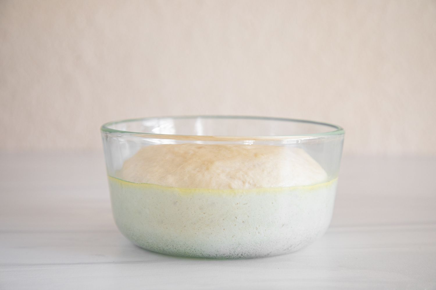 Dough rising in a glass bowl for a A Guide to Baking Yeast.