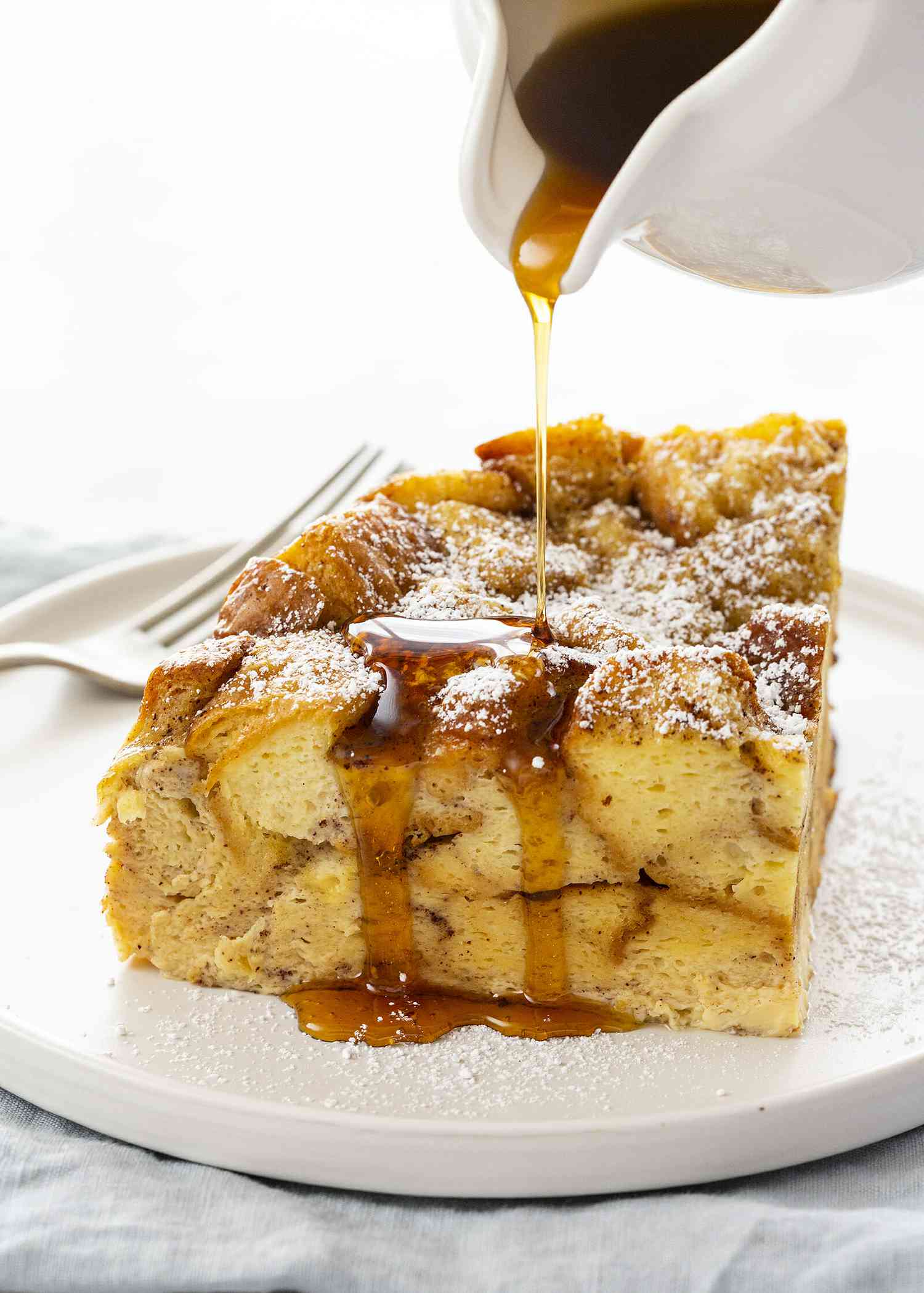 Crockpot French Toast Casserole - slice french toast casserole on plate with syrup and fork