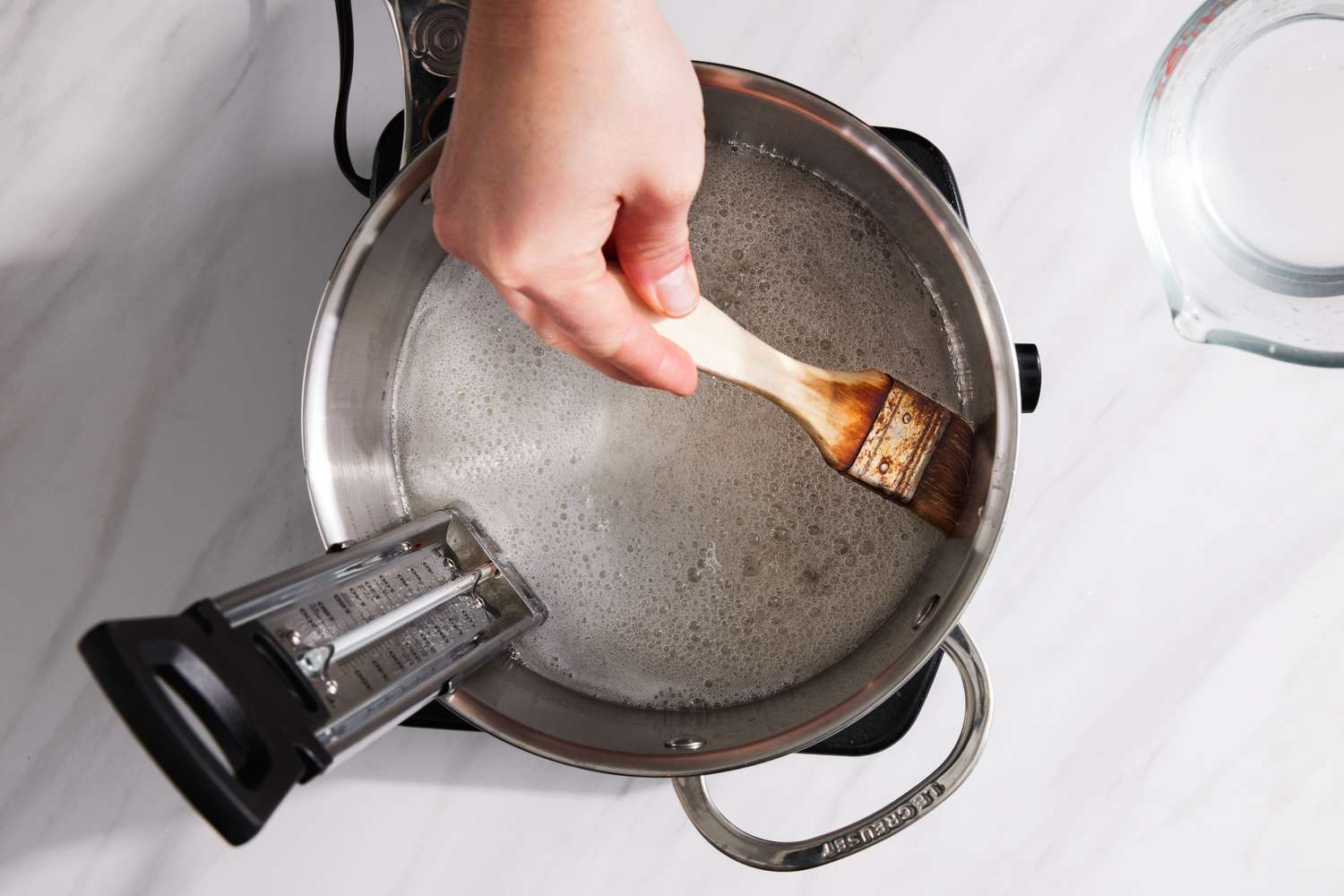 Pastry Brush Used on Inner Edges of Sauce Pan with Boiling Sugar and Cornstarch and a Candy Thermometer for Peppermint Caramel Square Recipe