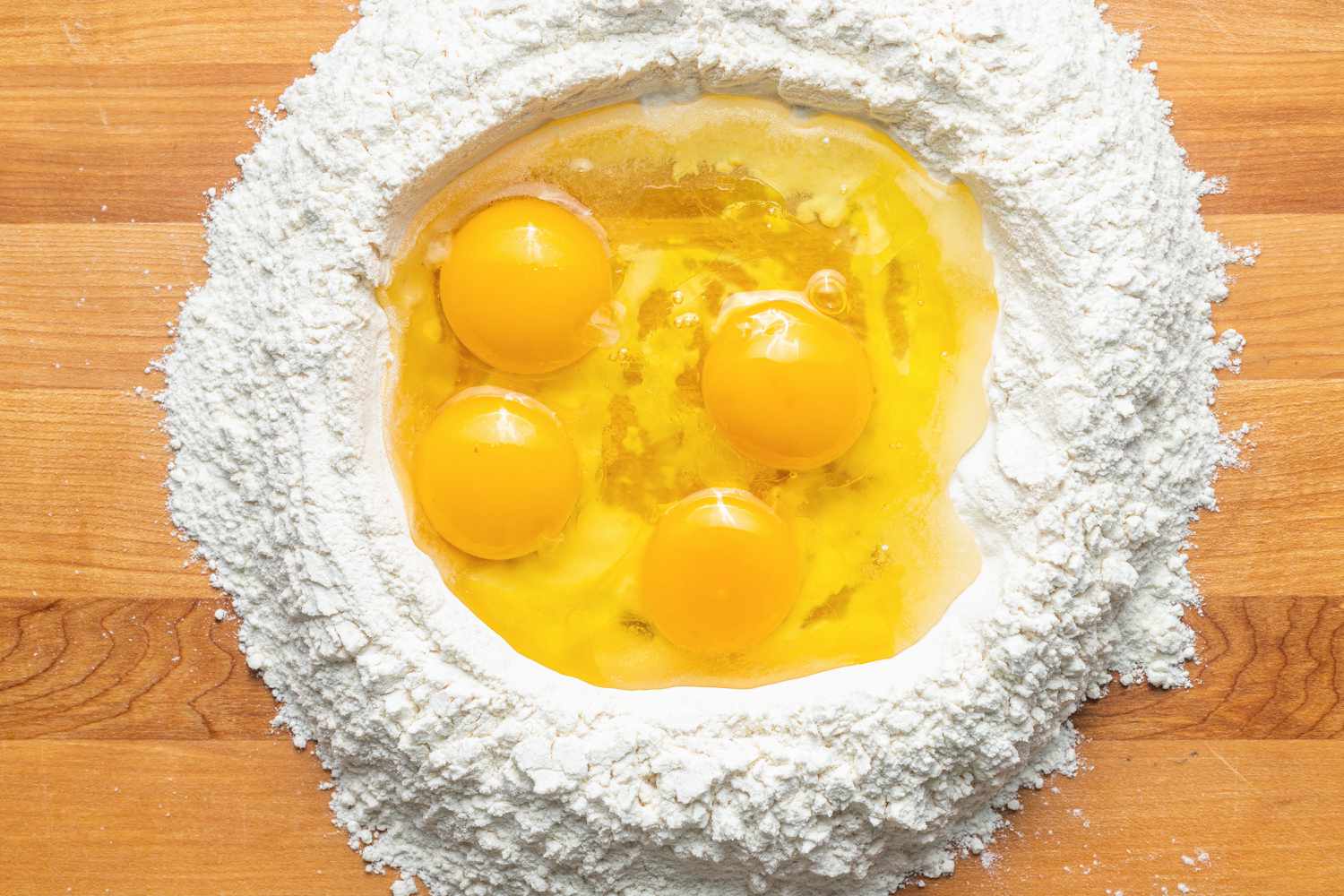 On a Counter, a Mound of Flour With an Egg Well for Homemade Tagliatelle 