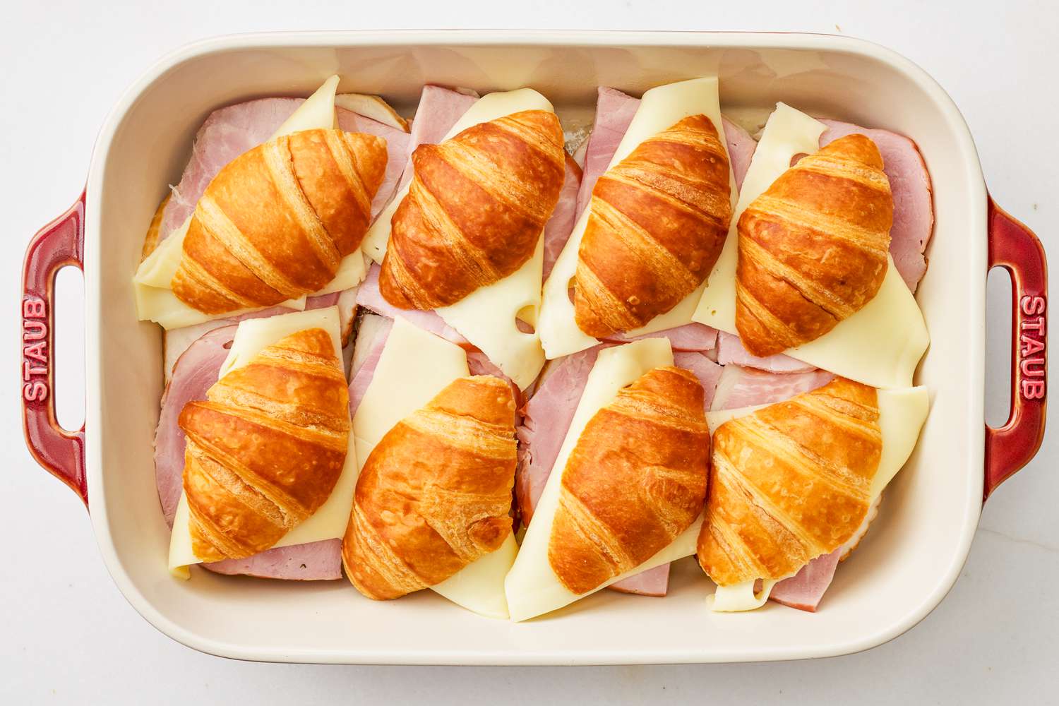 Monte cristo sandwiches assembled and snuggly placed in a casserole dish for Wet ingredients whisked together for monte cristo croissant casserole recipe