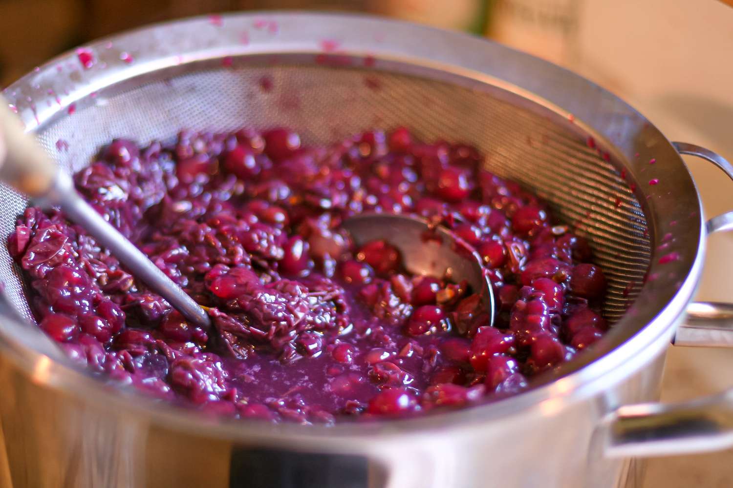 Straining grapes to make a grape drink.