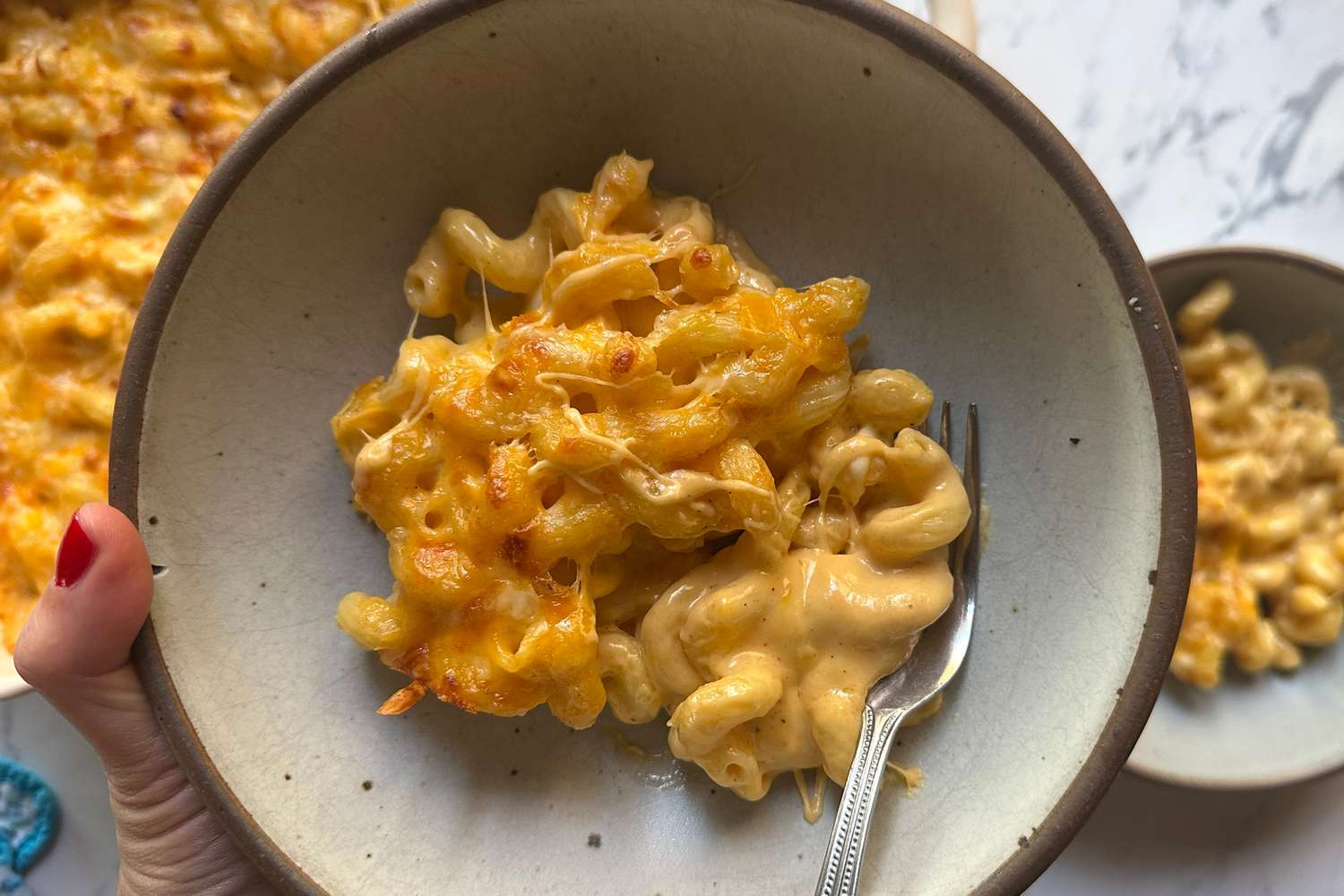A plate of macaroni and cheese with a fork viewed from above