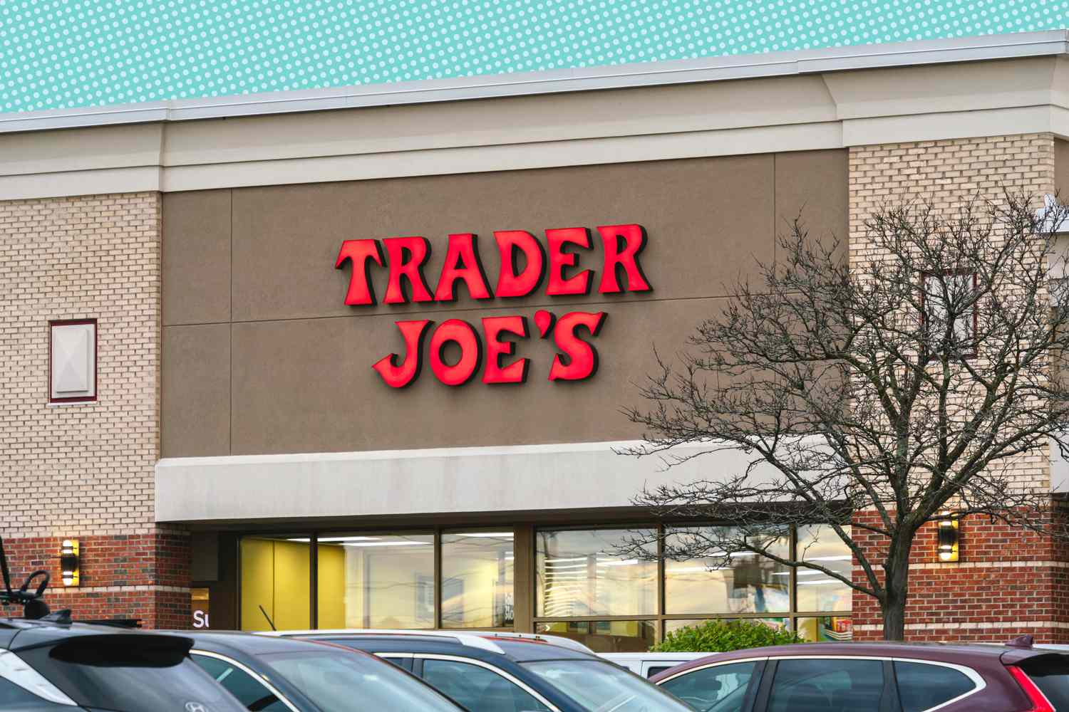 Exterior of a Trader Joes store with parked cars in the foreground