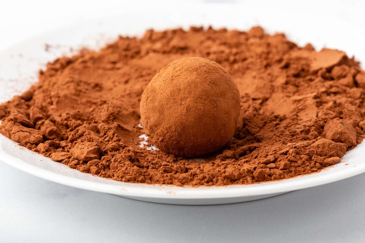 Rolling ganache balls in cocoa for a chocolate truffle recipe.