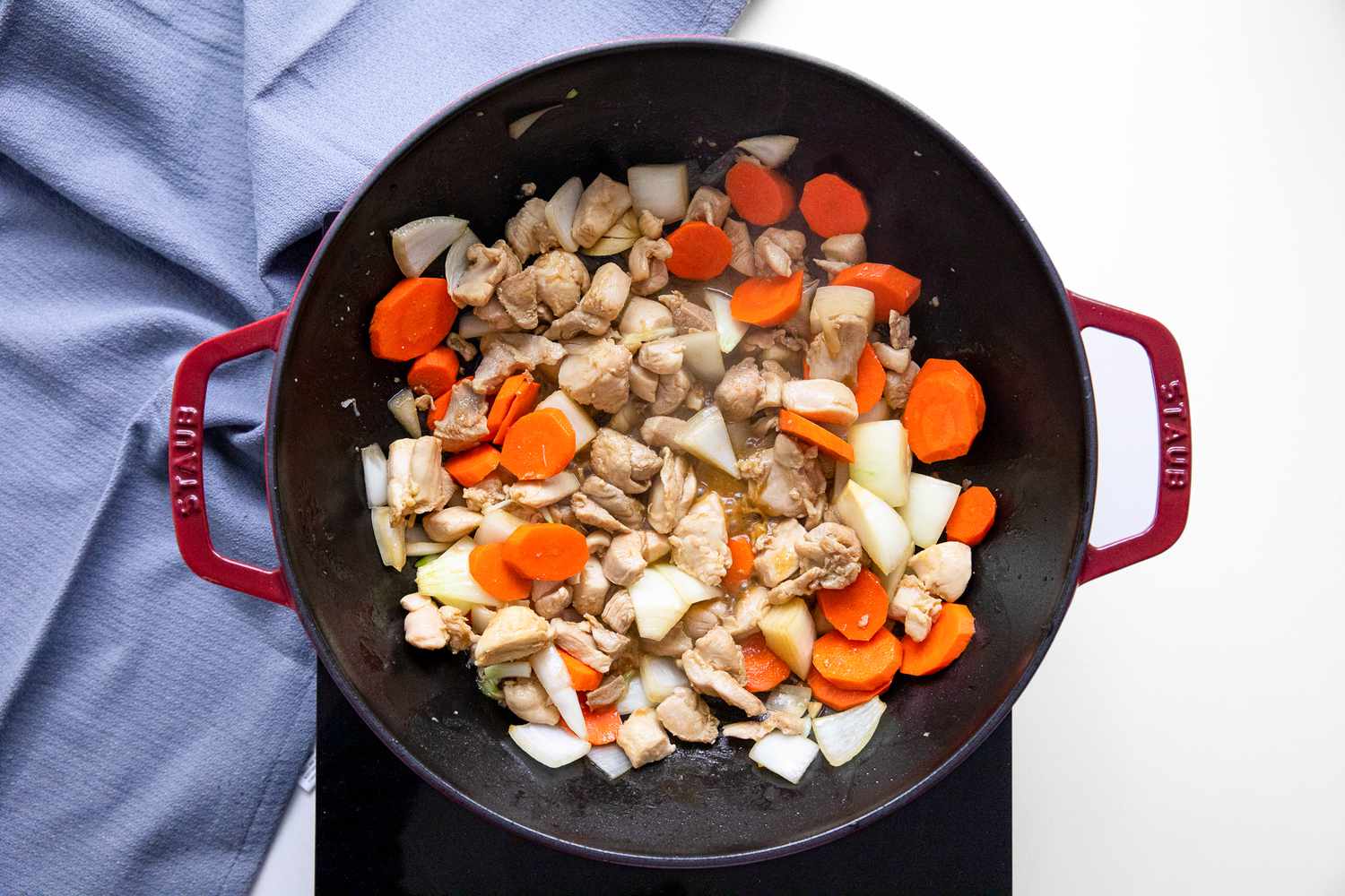 Onions and Carrots Added the Wok on a Portable Burner, and Next to It, a Blue Kitchen Towel for Chop Suey RecipeChop Suey