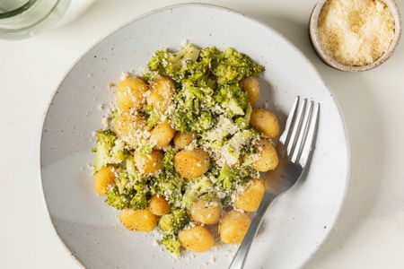 Gnocchi with broccoli and cheese on a plate with a fork