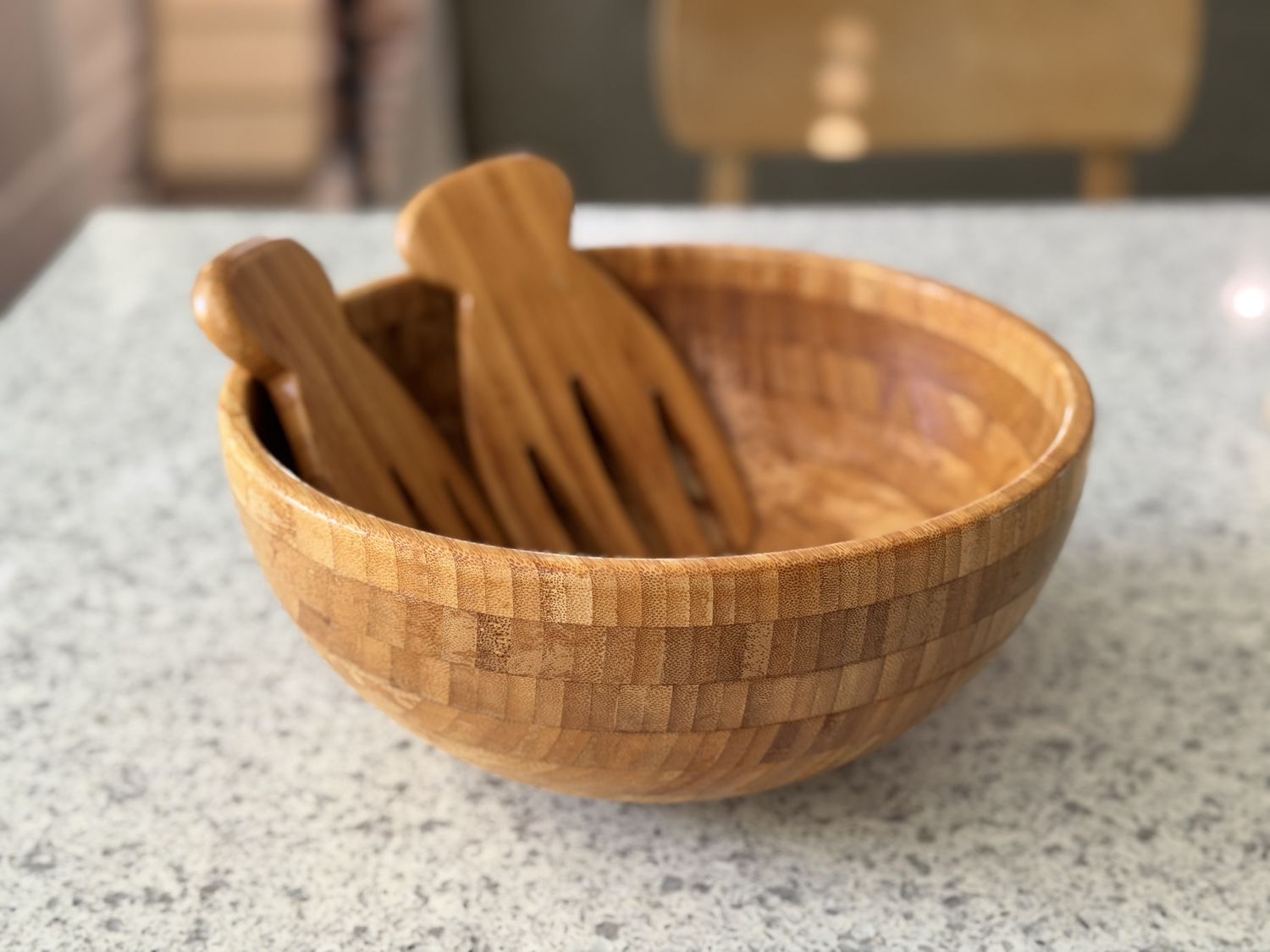 Wooden salad bowl and utensils on a countertop