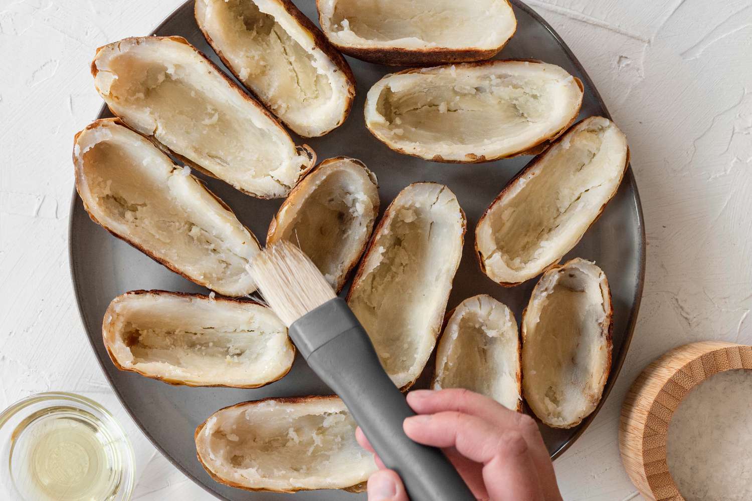 Brushing potatoes in olive oil