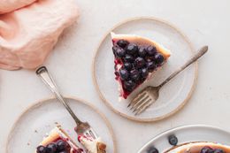 Top down view of a slice of blueberry cheesecake with a fork.