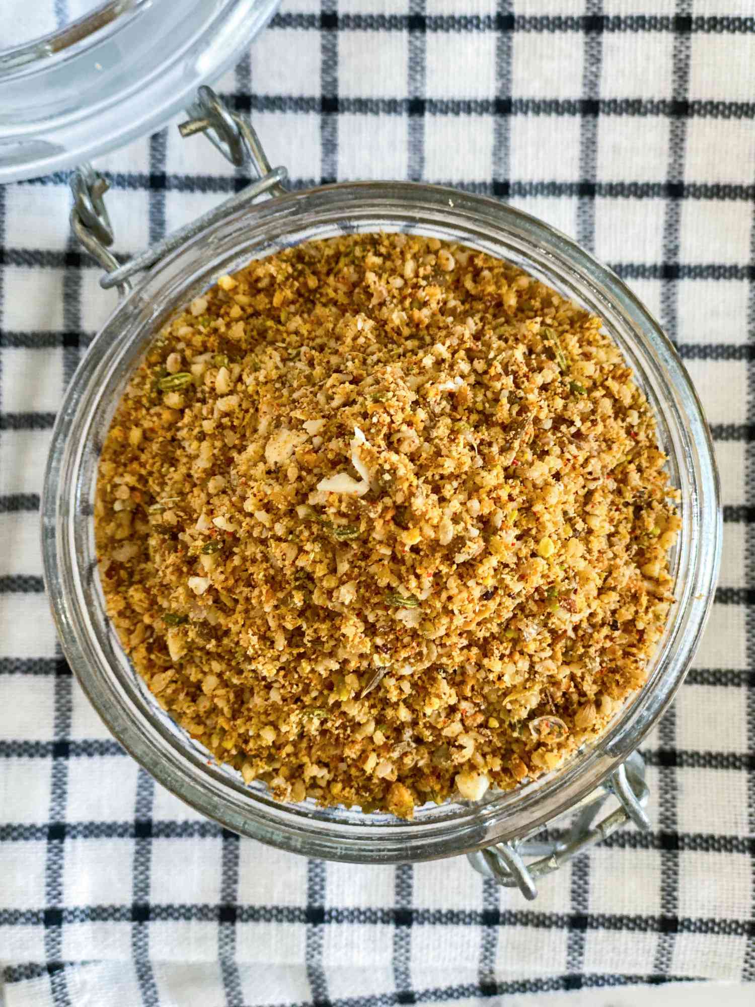 Overhead view of Dukkah spice blend in a glass container.