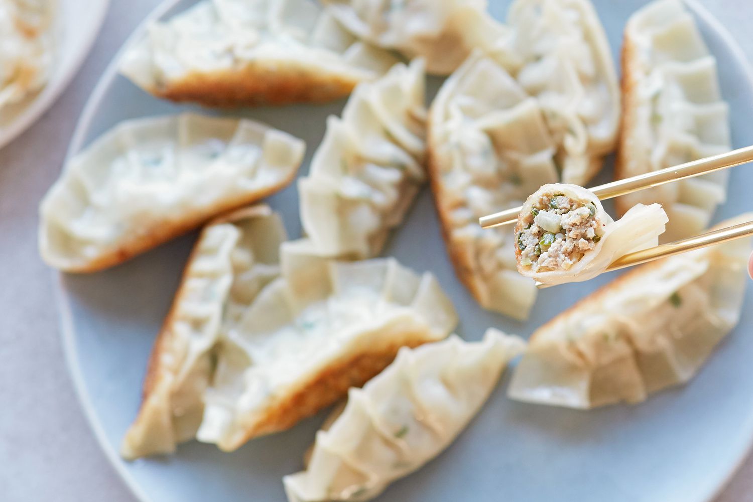 Overhead view of Korean pork and chives dumplings on a plate.