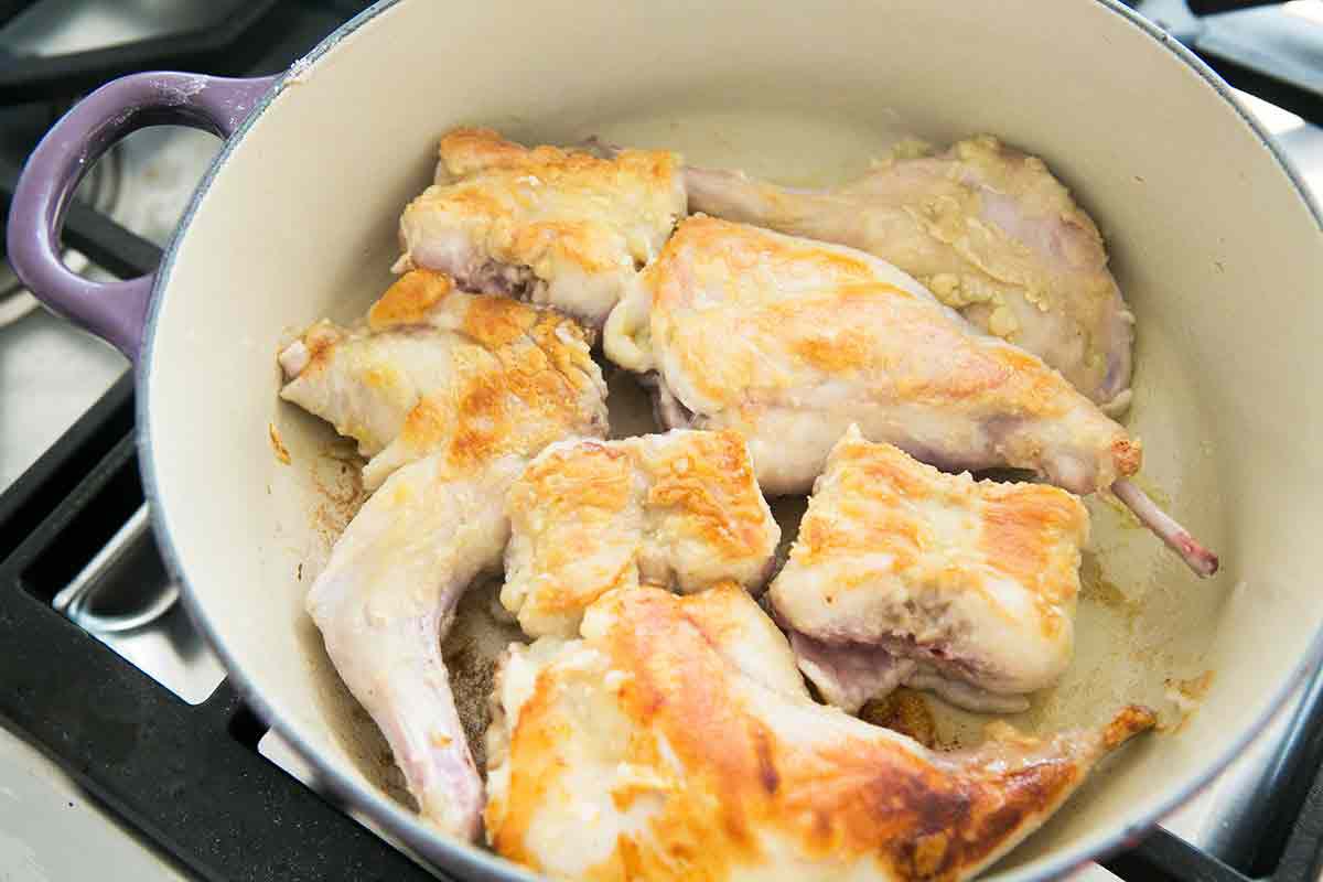brown rabbit pieces in butter for braised rabbit recipe