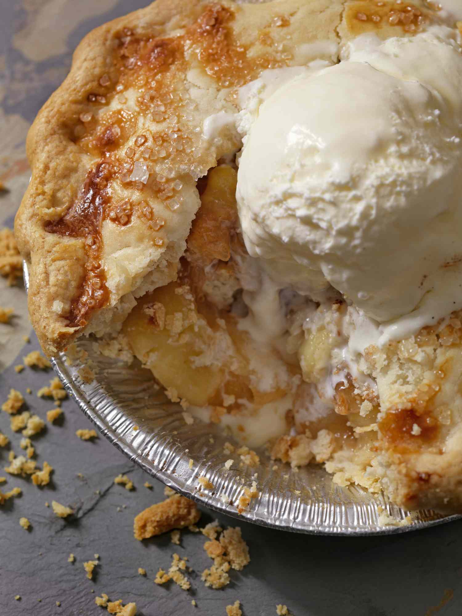 A slice of apple pie with a scoop of ice cream on top