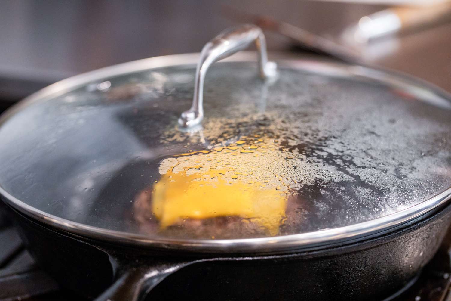 Lid Added to Cast Iron Skillet to Help Melt the Cheese on the Burger
