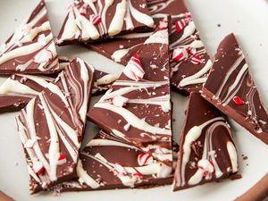 Pieces of chocolate peppermint bark on a plate featuring a mix of dark and white chocolate with candy cane bits