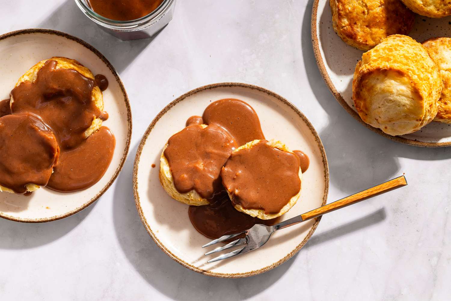 Plates of biscuits covered in chocolate gravy served on a table