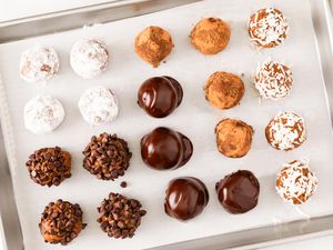 Overhead view of sheet of rum balls from Granny's Rum Balls recipe with various coatings and placed on a baking sheet with parchment paper