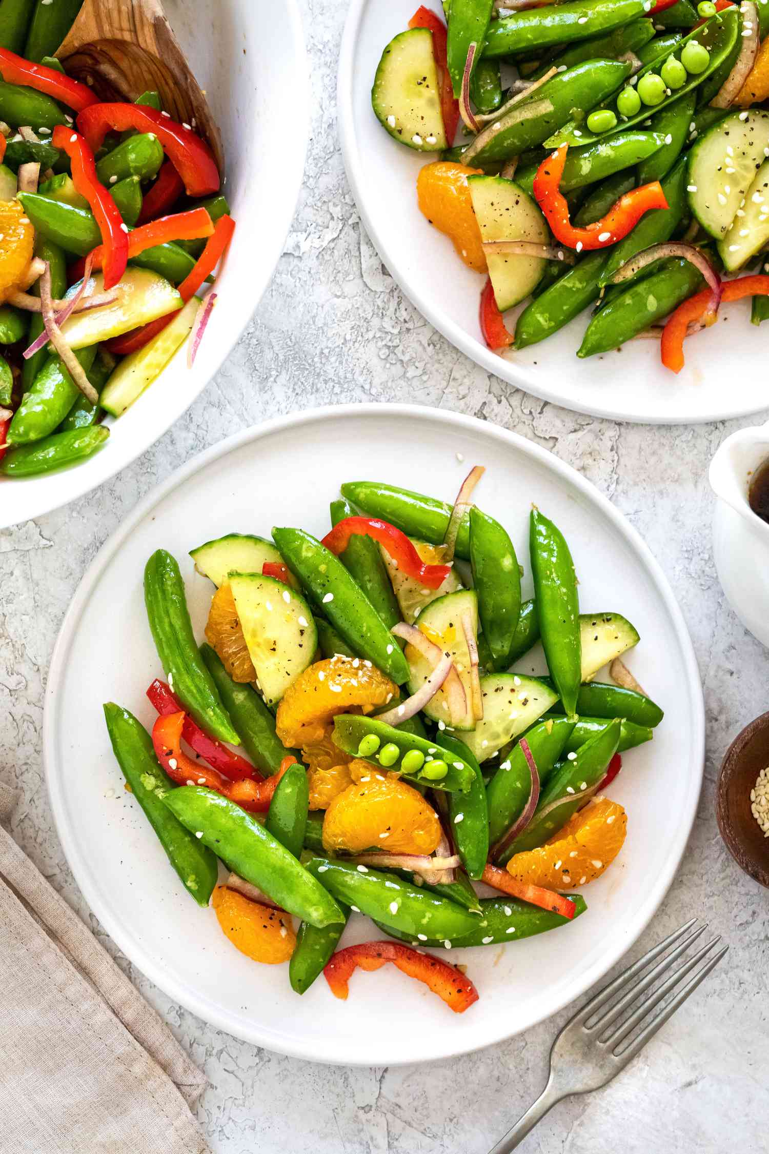 Sesame soy and sugar snap pea salad on plates.