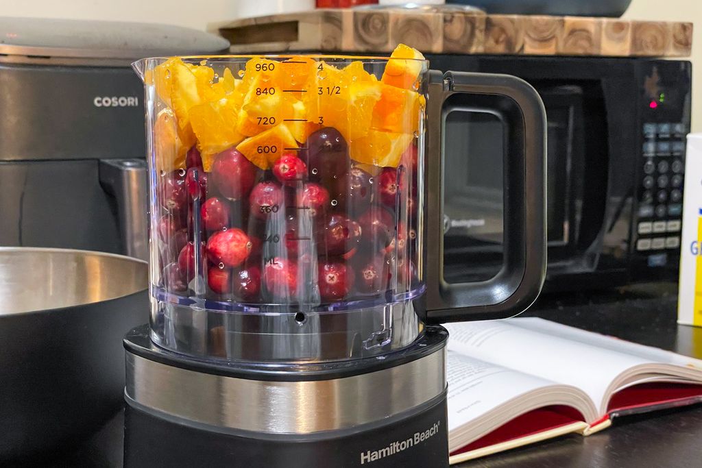 Cranberries and orange pieces in a food processor