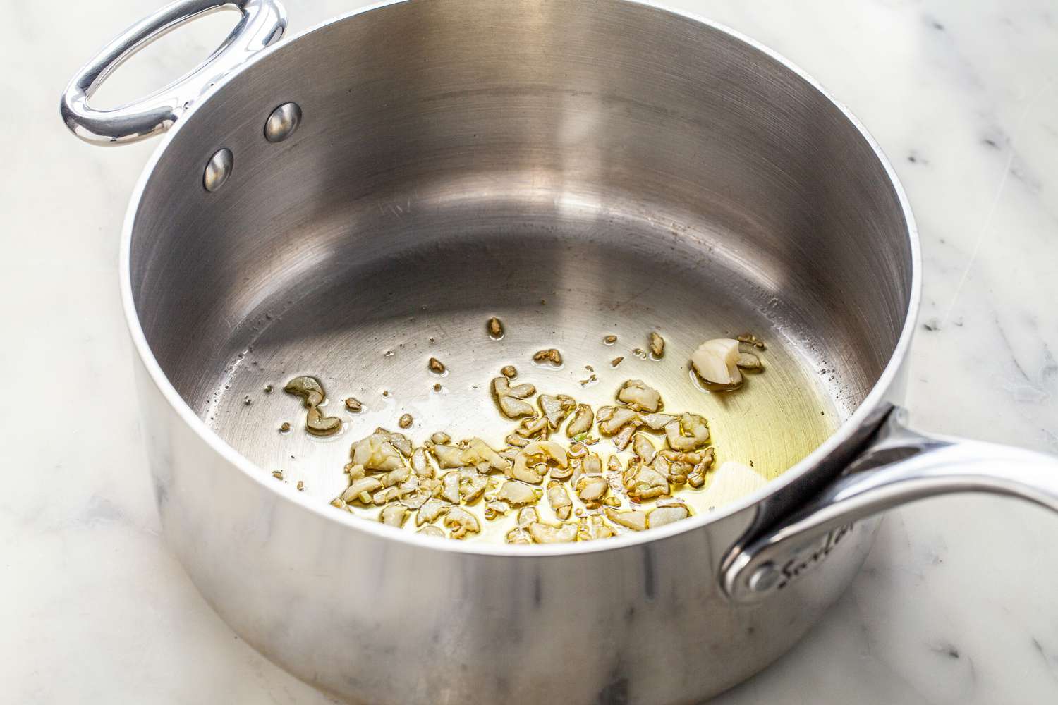 In a Pot, Sliced Garlic Cooking in Oil for Homemade Marinara Recipe