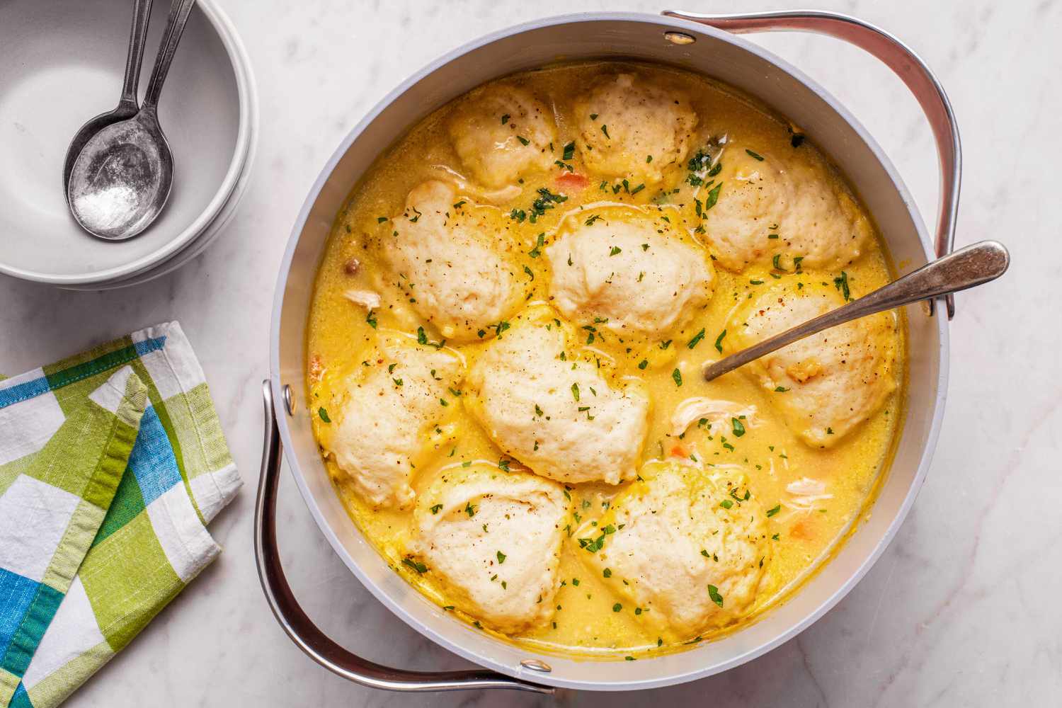 Easy Chicken and Dumplings in a pot, bowls, spoons, and napkins on the side