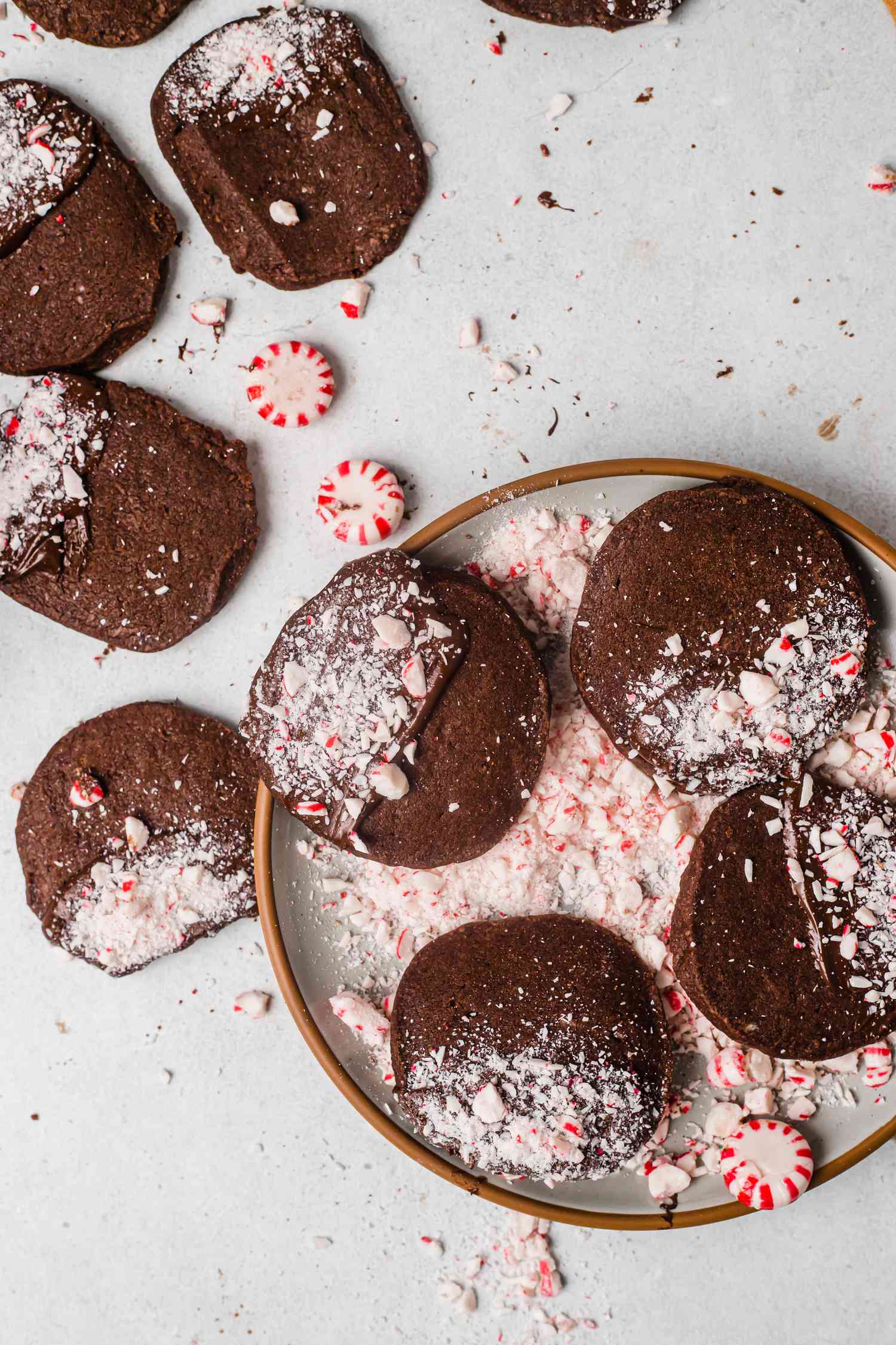 Overhead view of holiday chocolate and peppermint shortbread on a platter with crushed peppermint around it.
