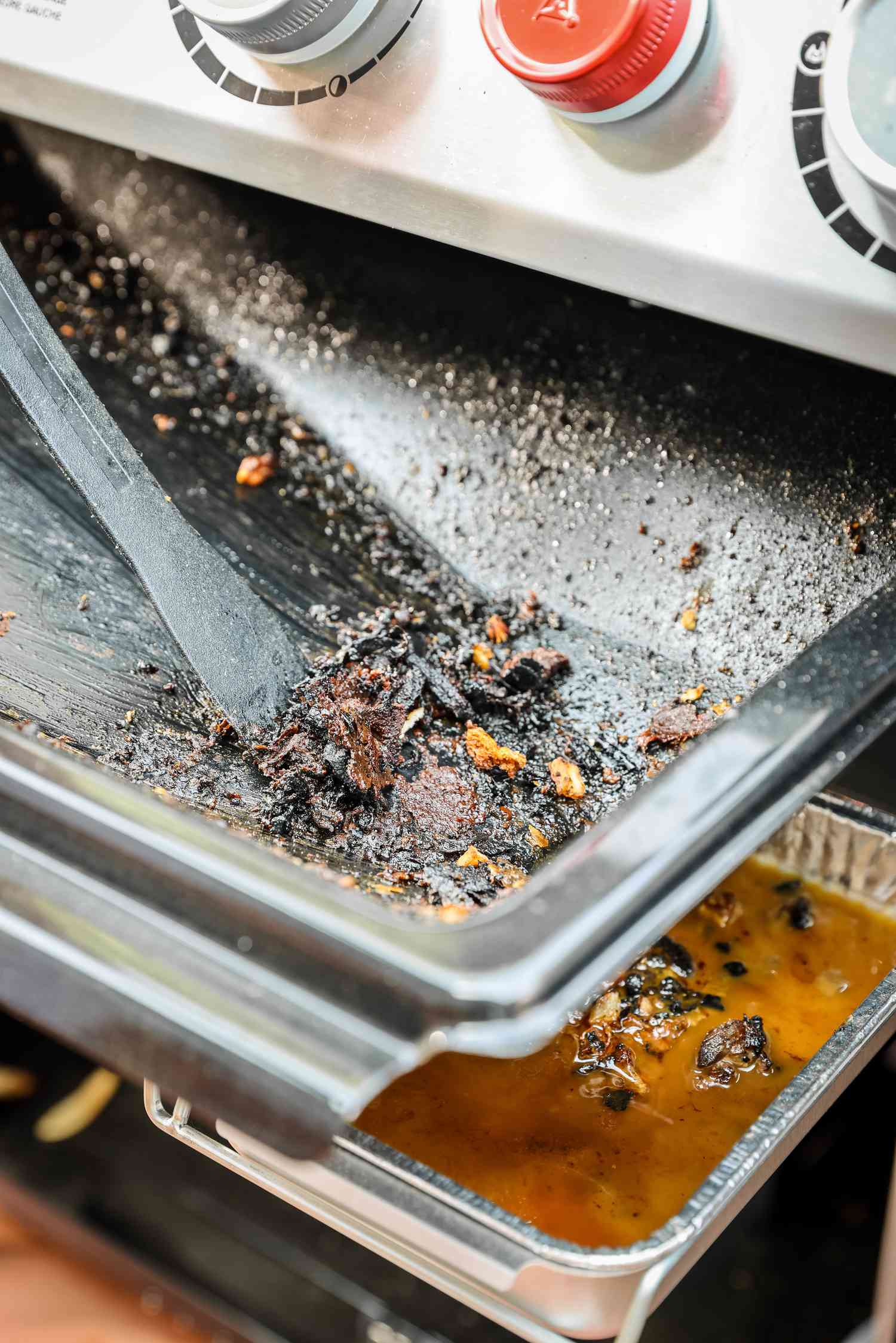 Gas Grill's Grease Pan Scraped and Cleaned 