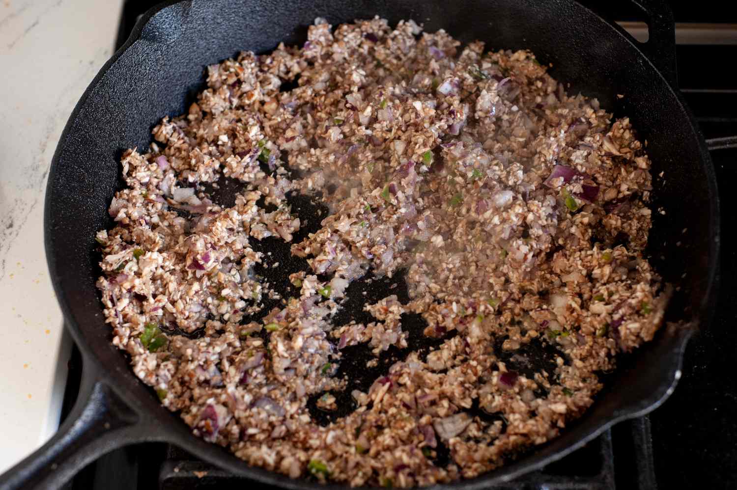 Minced Vegetables Cooking in a Cast Iron Skillet for Black Bean Smash Burger