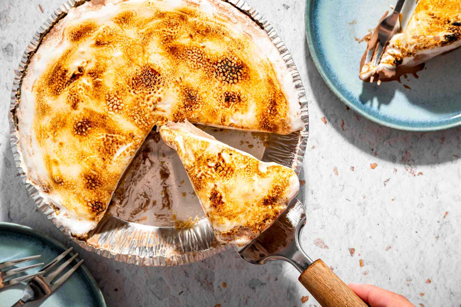 A sliced frozen smores pie with a piece being lifted on a serving spatula