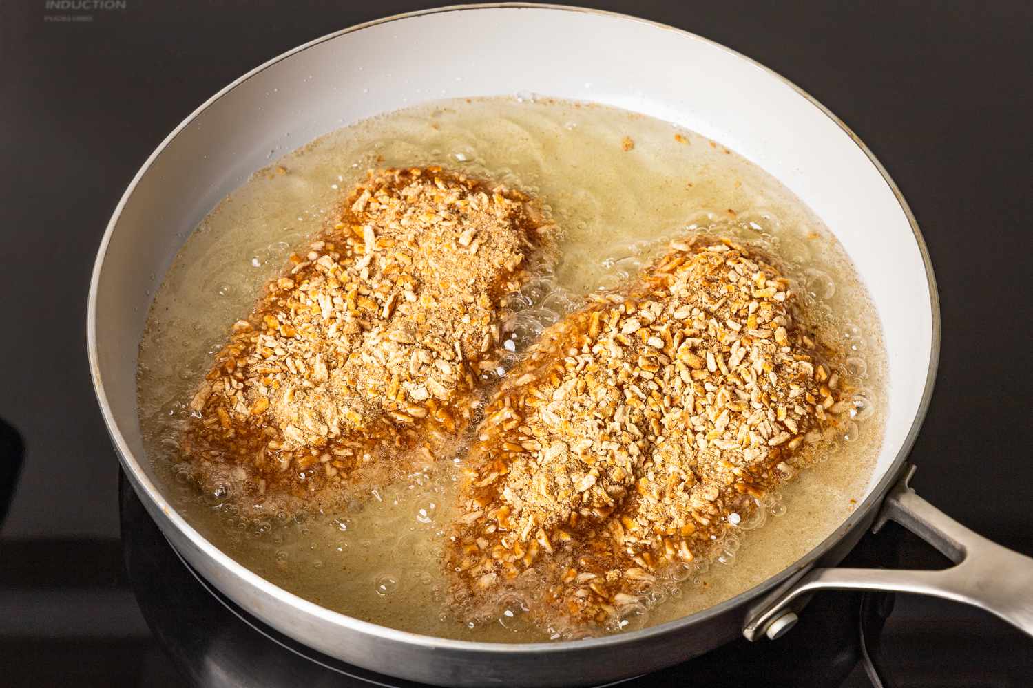 pretzel chicken cutlets pan frying on the stove