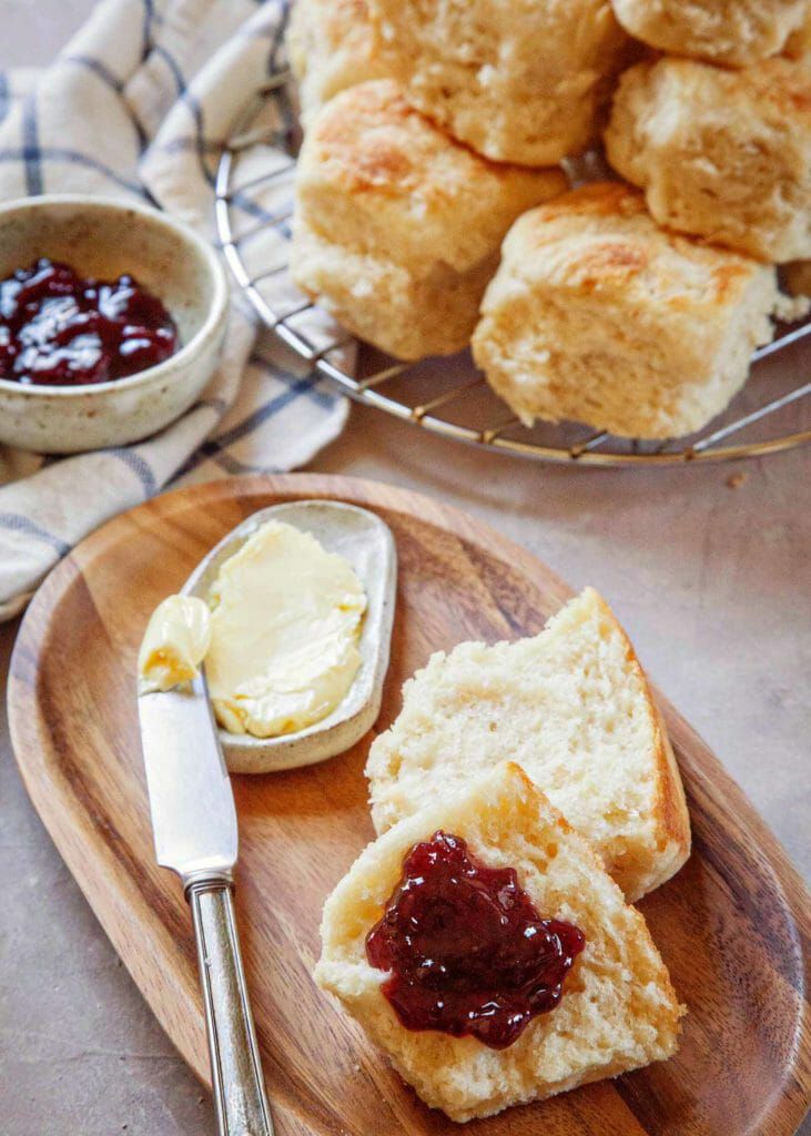 Angel biscuits with jam and butter on a wooden plate