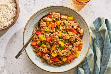 A serving bowl of cooked ground turkey and peppers with white rice on the side