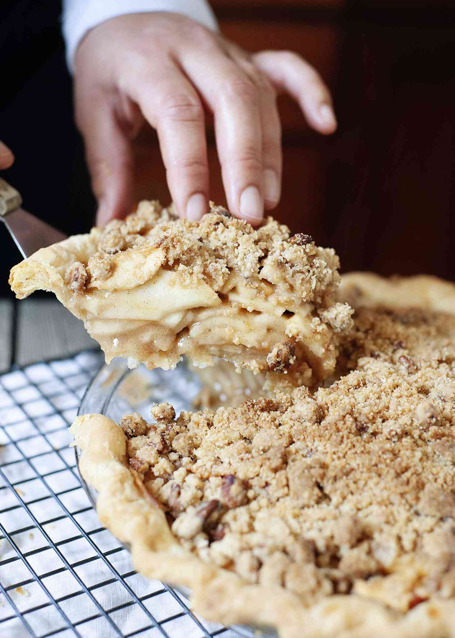 Woman lifting a slice of pie out of a pie plate.
