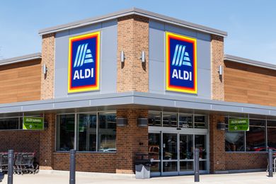 Ground level view of the front entrance to an Aldi store showing the Aldi sign above the entrance