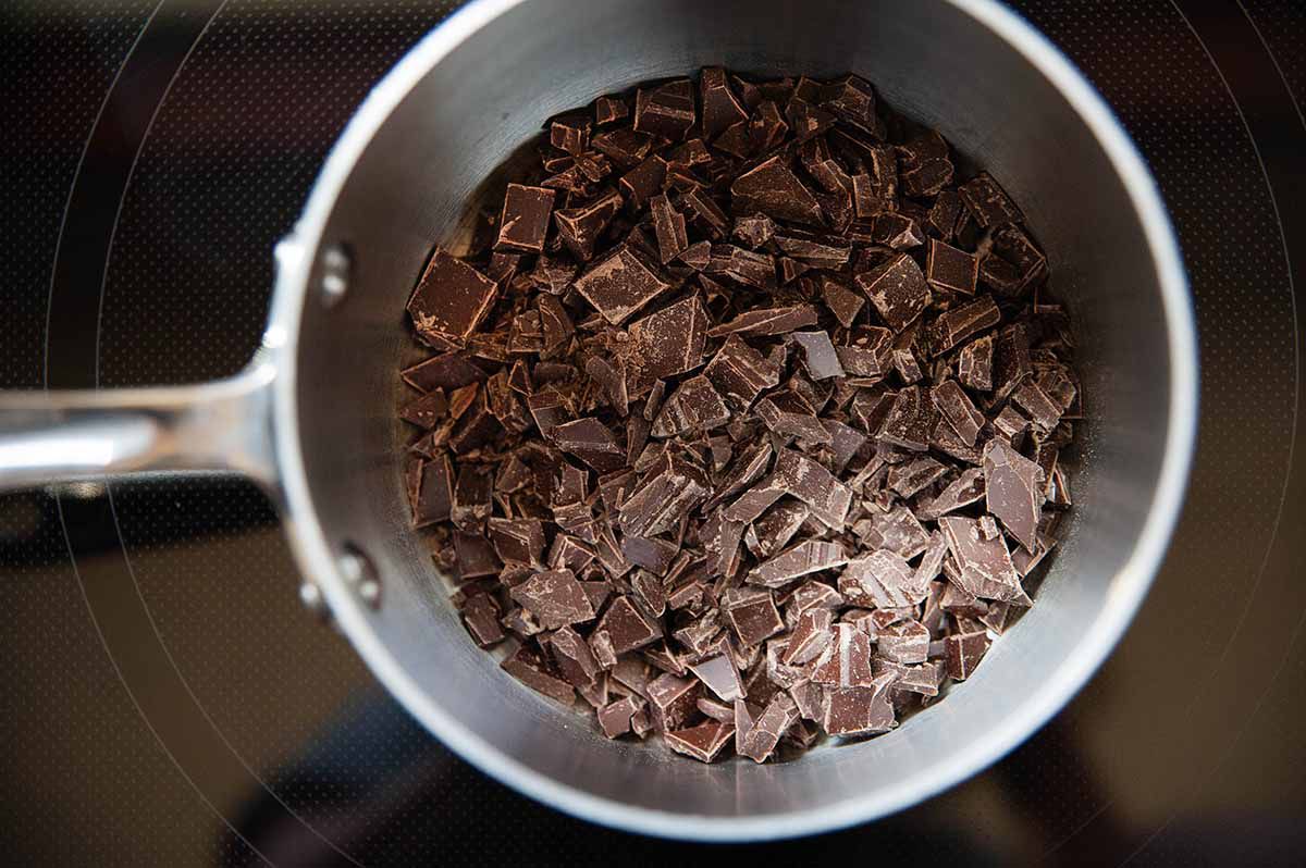 Chopped chocolate to in a bowl for homemade cheesecake.