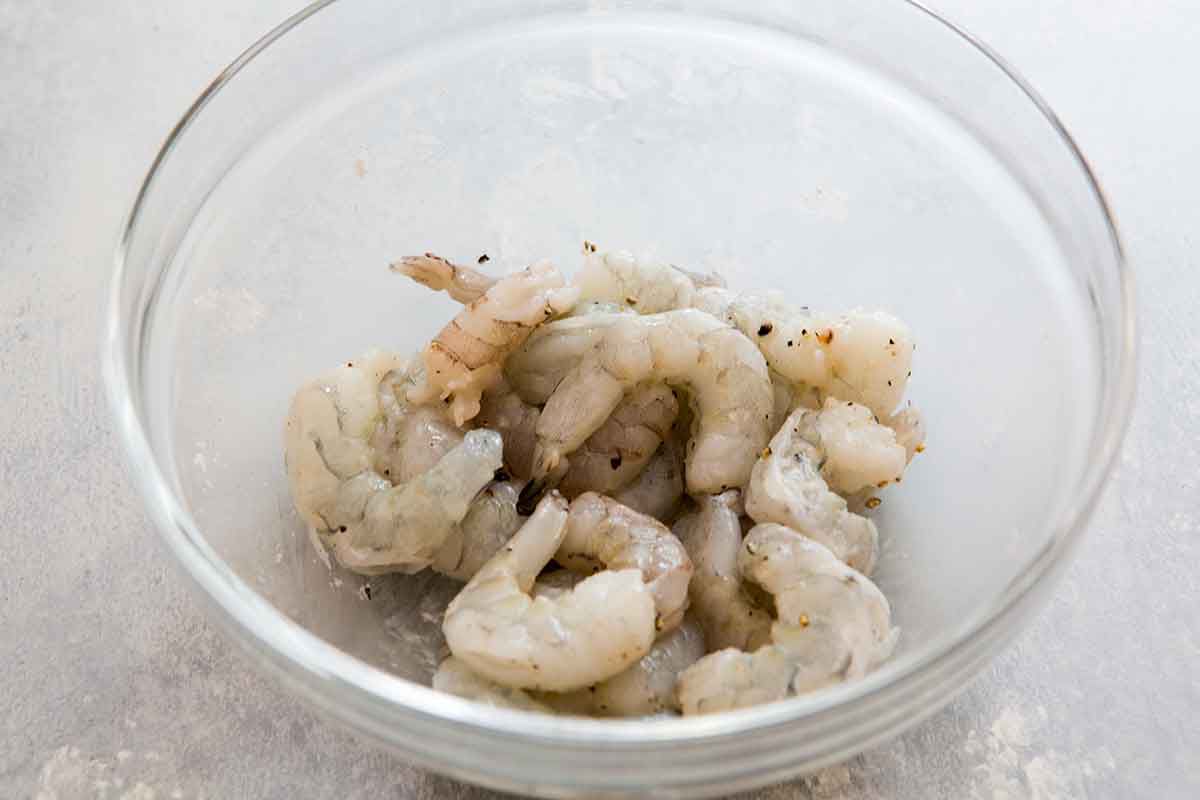 Raw shrimp resting in a glass bowl